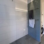 Badewanne und Dusche werden durch eine verflieste, dem Raum angepasste, frei zugängliche Duschzone ersetzt